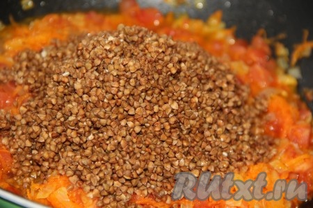 Гречку перебрать и хорошо промыть. Добавить гречку в сковороду к помидорам, луку и моркови.