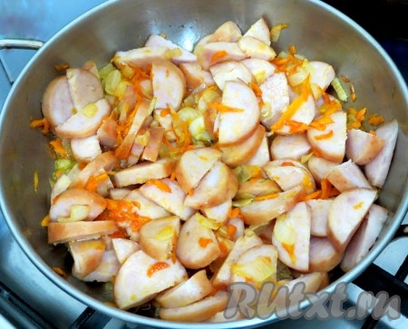Лук и морковь обжариваем на небольшом огне до мягкости, минут 5, периодически помешивая. Затем добавляем нарезанную полукольцами колбасу и продолжаем обжаривать, иногда помешивая, до золотистого цвета овощей и колбаски. 
