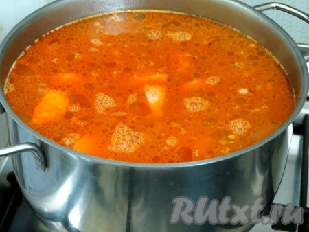 За это время картофель сварился. Добавляем в суп натёртые солёные огурцы вместе с рассолом, обжаренные колбасу, лук, морковь и варим всё вместе ещё 10 минут.
