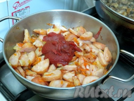 К обжаренным ингредиентам добавляем томатную пасту, хорошо перемешиваем и обжариваем ещё минуты 2.
