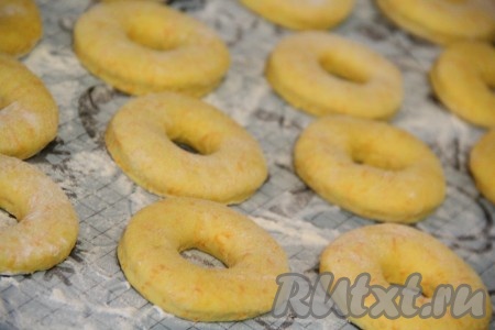 Переложить получившиеся пончики из тыквы на поверхность, припорошенную мукой, накрыть полотенцем и оставить минут на 30-40. Пончики увеличатся в объёме.