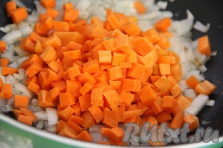 Затем к обжаренному луку выложить морковку, перемешать и обжаривать её до мягкости (в течение 7-8 минут), периодически помешивая.