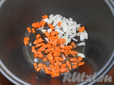 В чашу мультиварки влить растительное масло. Поместить в чашу нарезанные кубиками репчатый лук и морковь. Выставить режим "Жарка" на 10 минут (крышку можно не открывать).
