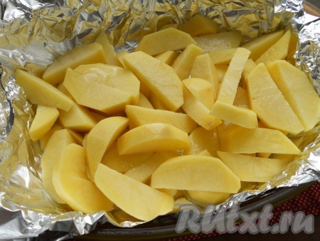 Форму для запекания застелить фольгой, сложенной в 2 раза. Влить растительное масло. Картофель очистить, помыть и нарезать вдоль на 4-6 частей. Поместить картофель в форму для запекания, посолить.
