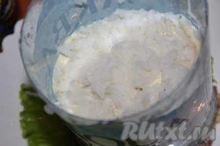 Затем выложить рис, разровнять, посолить и поперчить по вкусу. Смазать слой с рисом майонезом.
