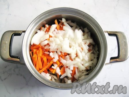 Репчатый лук и морковь почистить и помыть. Лук нарезать произвольно, а морковь - соломкой. Добавить лук с морковью к куриным желудкам в кастрюлю. Налить подсолнечное масло, перемешать.
