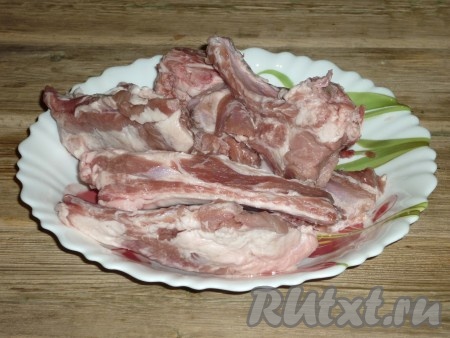 Свиные ребра вымыть и разделить на порционные куски, разрезав между косточками.
