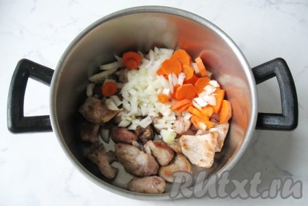 Поджаренную свинину выложить в кастрюлю. Репчатый лук и морковь почистить, помыть и нарезать. Добавить овощи к жареному мясу.
