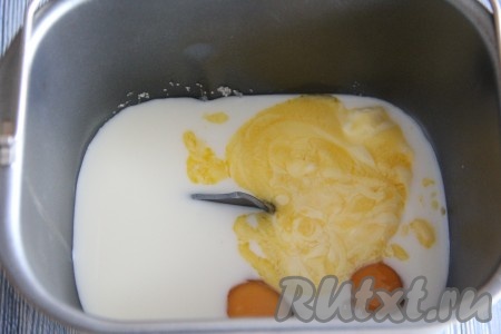 В ведёрко хлебопечки влить тёплое молоко, добавить яйца, сахар и ванильный сахар. Масло растопить и добавить в ведёрко. 