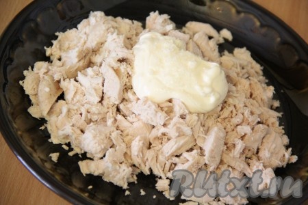 На плоскую тарелку выложить куриную грудку и добавить 1 столовую ложку майонеза и соль.