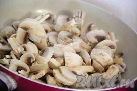 Выложить шампиньоны в сковороду с добавлением растительного масла.