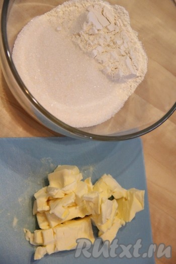 Пока наше тесто поднимается, можно заняться приготовлением штрейзельной крошки. В глубокой миске соединить сахар и муку. Холодное масло порубить ножом на кусочки.