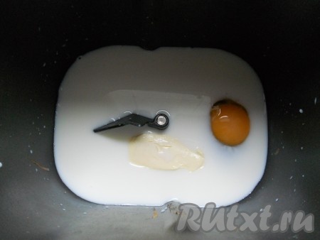 В ведерко хлебопечки влить теплое молоко, добавить размягченное сливочное масло и яйцо, слегка перемешать.
