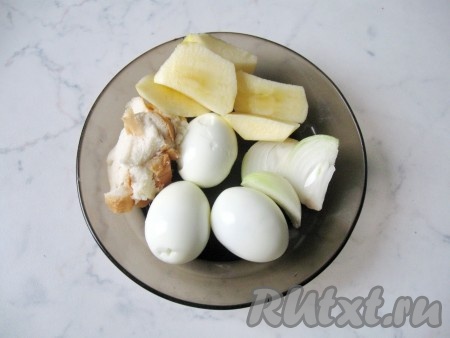 Яйца сварить вкрутую. Для этого выложите их в кастрюлю с холодной водой и варите 10 минут с момента закипания. Затем залейте холодной водой и охладите.  Очистите яйца.  Репчатый лук почистить и помыть. Яблоко помыть, почистить и нарезать. Белый батон замочить в холодной воде и отжать. 
