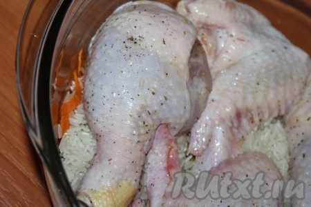 Поверх риса выложить курицу, добавить два стакана куриного бульона или воды.
