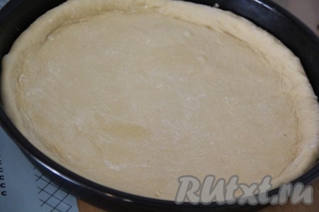 Выложить раскатанное тесто в форму для выпечки (у меня круглая форма 30 см), смазанную растительным маслом, формируя бортики.
