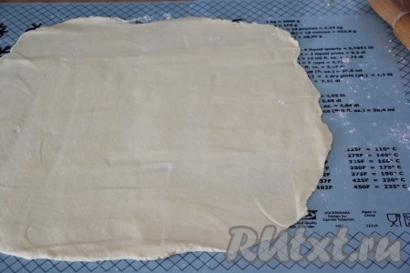 Охладившееся творожное тесто на посыпанной мукой поверхности раскатать с помощью скалки в тонкий пласт.