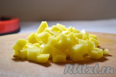 Картофель очистить, помыть, нарезать средними кубиками, отправить в кастрюлю с куриным бульоном и мясом. 