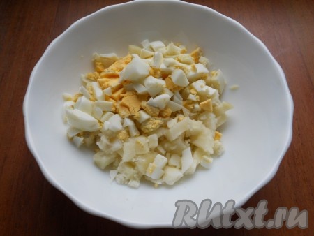 Картофель отварить в кожуре, остудить и очистить. Отварить вкрутую яйца, остудить и очистить. Нарезать небольшими кубиками яйца и картофель.
