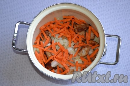 Морковку и лук выкладываем в кастрюлю к свинине.
