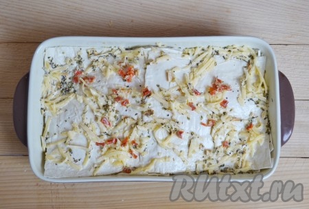 Чередуя куски лаваша и сыр, заполнить форму для выпечки. Верхний (последний слой лаваша) посыпать паприкой и сыром.
