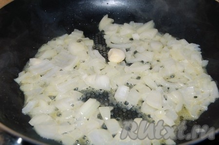 На отдельной сковороде на сливочном масле обжарить до мягкости мелко нарезанный репчатый лук с чесноком, периодически помешивая.