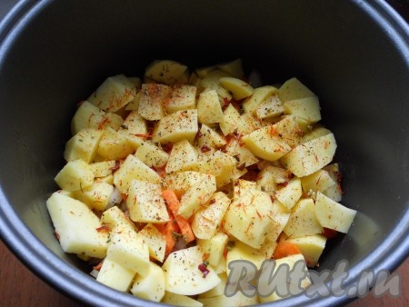 Далее добавить слой нарезанного кубиками картофеля. Посолить, посыпать специями, добавить паприку, второй зубчик чеснока (нарезать) и шафран.
