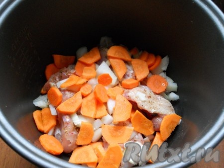 Сверху курицы выложить лук, нарезанный на средние кусочки, и морковь, нарезанную на кружки (или полукружки).
