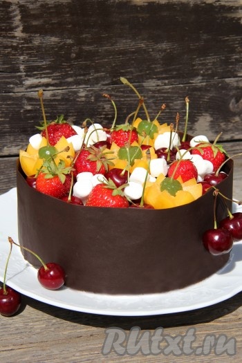 После того как шоколад застынет, аккуратно снять пергаментную бумагу. Верх торта украсить свежими ягодами и фруктами, можно просто посыпать тёртым шоколадом или цветной посыпкой. Вот такой красавец получился!
