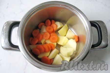 Морковь почистить, помыть и нарезать. Добавить в кастрюлю к картофелю.
