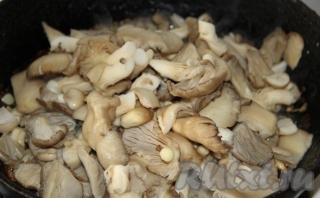 Когда лук подрумянится, добавляем крупно нарезанные вешенки (если нарезать мелко, грибы потеряются в картошке) и обжариваем, периодически помешивая, до испарения жидкости (в течение 10-15 минут). 
