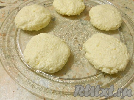 Сформировать мокрыми руками сырники. Тарелку из микроволновки чуть смазать растительным маслом и выложить на нее сырники на расстоянии 5-6 см.
