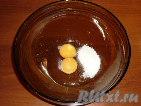 В небольшую ёмкость выложить 2 желтка (или 1 яйцо), перемешать с 1 столовой ложкой сахара до побеления массы. 