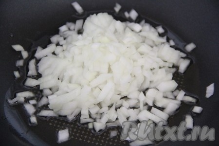 В глубокую сковороду влить растительное масло и поставить на огонь. Лук нарезать мелкими кубиками и добавить в сковороду.
