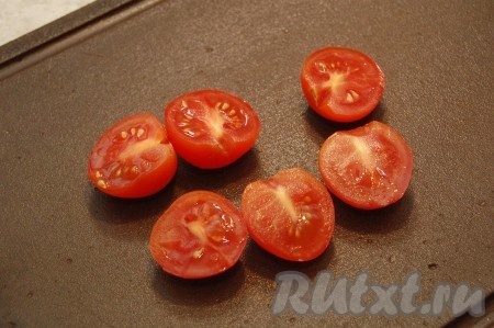 Нарезать томаты черри на половинки.