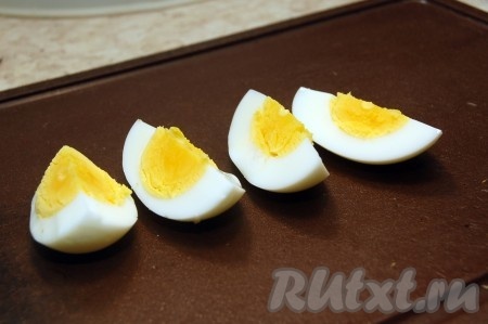 Яйцо вкрутую нарезать вдоль на четыре части.