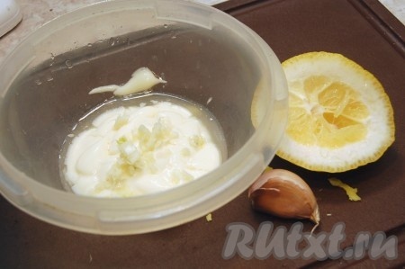 Для заправки салата с авокадо, креветками и яйцом в майонез выжать лимонный сок, выдавить чеснок через чеснокодавилку и тщательно перемешать.