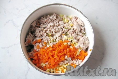 Морковь сварить в кожуре: вскипятить в кастрюле воду, выложить две моркови, накрыть кастрюлю крышкой и варить 25-30 минут до мягкости. Затем достать морковь из воды, охладить и почистить. Одну морковь оставить для украшения, а другую мелко нарезать и выложить в миску к остальным ингредиентам салата.
