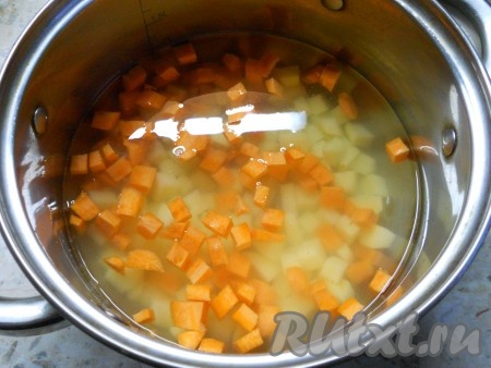 Поместить нарезанную морковку с картошкой в кастрюлю, залить водой, довести до кипения, уменьшить огонь, посолить по вкусу и варить до готовности (в течение минут 20). Овощи должны стать достаточно мягкими, но при этом картофель не должен развариться.