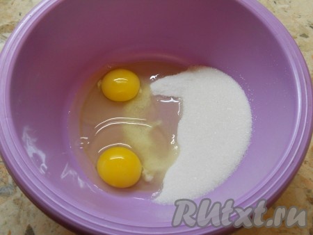В отдельную объёмную миску разбить яйца, добавить сахар.