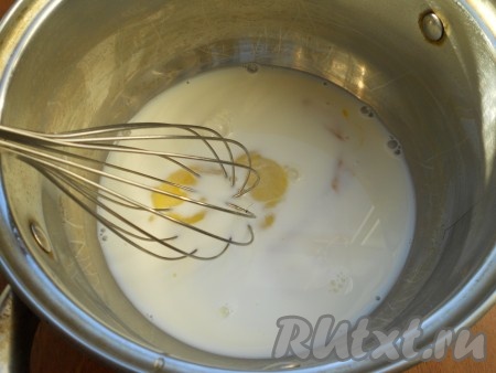 Для приготовления крема в небольшую кастрюлю поместить сырые желтки, влить молоко.
