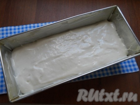 Продолговатую форму для кекса (у меня форма размером 12х25 сантиметров) смазать сливочным маслом, на дно поместить пергамент. Выложить подготовленное тесто, разровнять.