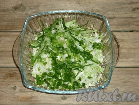 Мелко нарезанные лук и зелень добавить в салат с пекинской капустой, дайконом, морковью и огурцом, посолить и перемешать.
