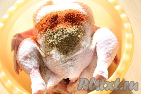 Курицу целиком выложить в глубокую миску, добавить специи и соль.