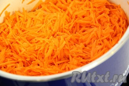  Морковь почистить и натереть на крупной тёрке. В глубокую кастрюлю влить воду и добавить морковь. Поставить кастрюлю на огонь.