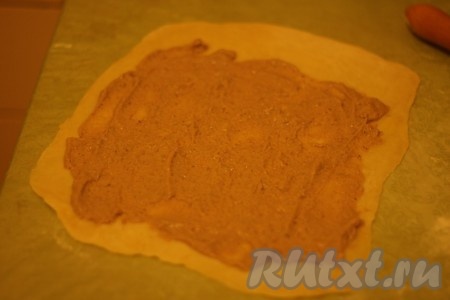 Подошедшее дрожжевое тесто тонко раскатать, сверху нанести тонким слоем начинку из орехов и груши, свернуть рулет. 
