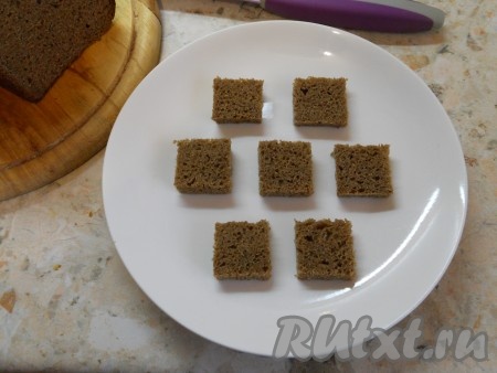 Ржаной хлеб нарезать на ломти толщиной не более 1 см. Обрезав корочки, разрезать хлеб на небольшие квадратики, поместить их на блюдо.
