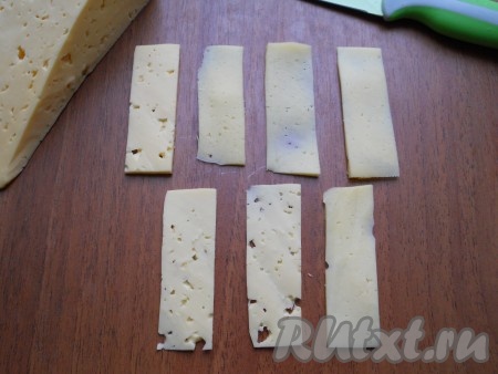 Твердый сыр нарезать тоненькими пластинами, размером примерно 7 см на 2,5 см.
