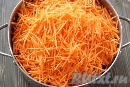 Морковь очистить и натереть на тёрке для моркови по-корейски. Добавить морковь в кастрюлю к овощам.
