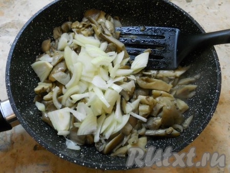 Обжаривать грибы на среднем огне минут 10-15 - до выпаривания жидкости. Вешенки периодически следует перемешивать. Далее в сковороду добавить нарезанный репчатый лук и влить соевый соус.
